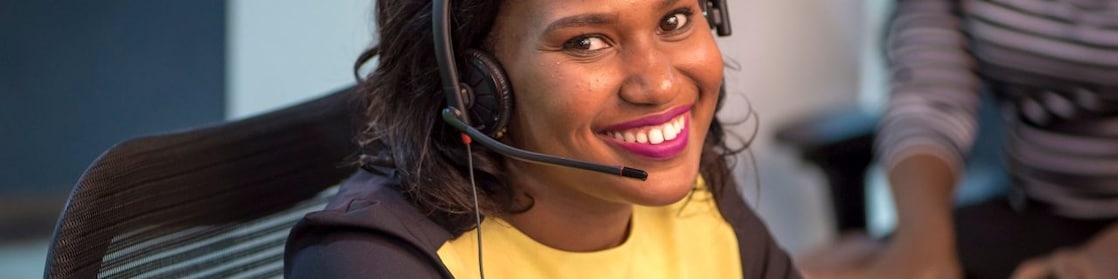 Collaboratrice souriante au téléphone avec un client