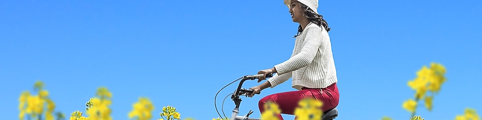 Une jeune femme fait une promenade à vélo dans un champ en été