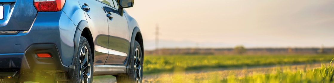 Voiture rouge circulant sur une route au bord d'une rivière