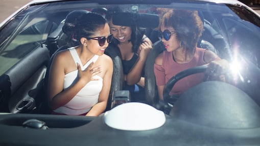 Une jeune femme consulte les instructions affichées sur l'écran de navigation intégré de sa voiture