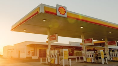 Soleil se levant derrière une station-service Shell