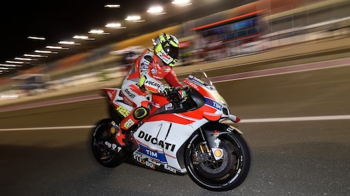 Pilote Ducati roulant vite sur une moto, sur un circuit, de nuit.