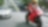 Moto rouge et conducteur sur une route avec des voitures et des bâtiments dans l’arrière-plan.