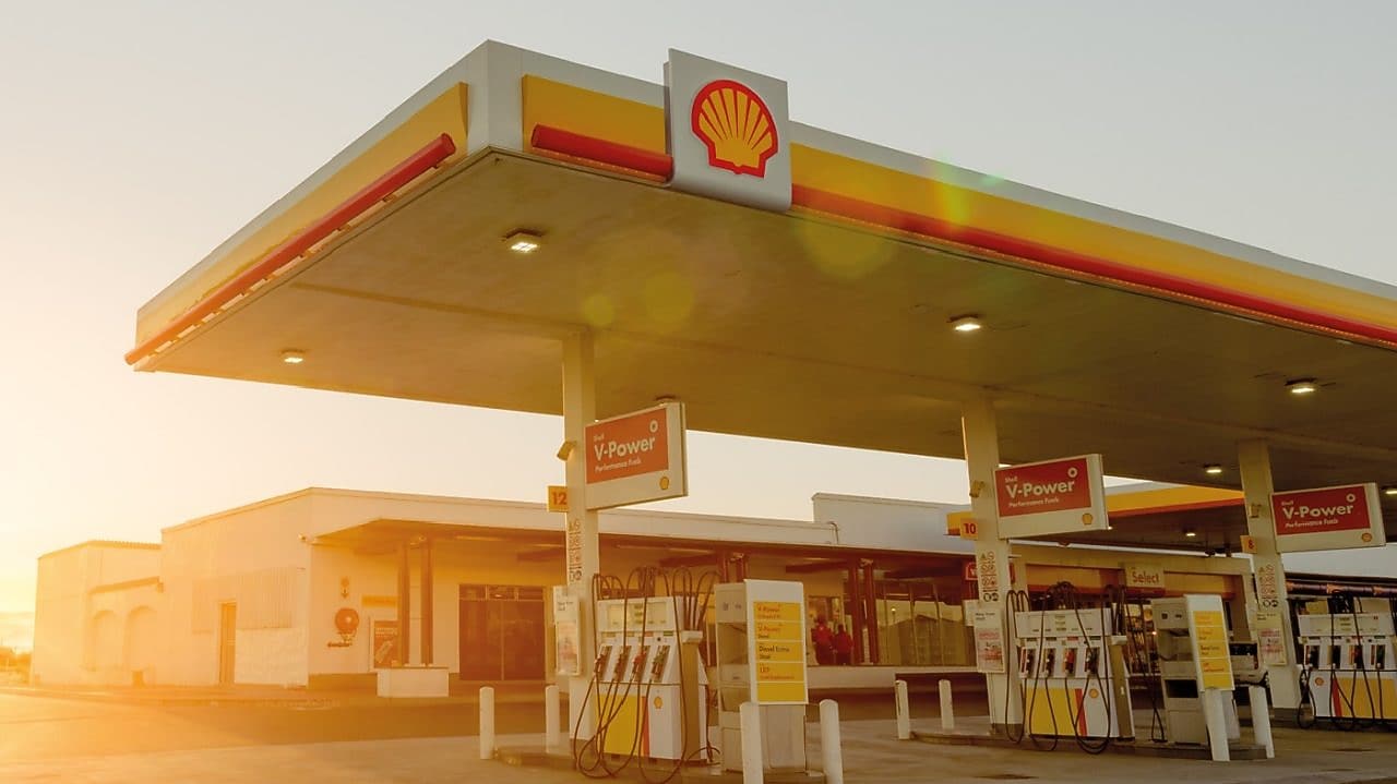 Soleil se levant derrière une station-service Shell