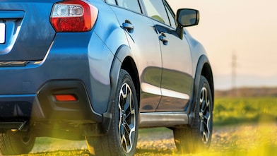 Voiture rouge circulant sur une route au bord d'une rivière